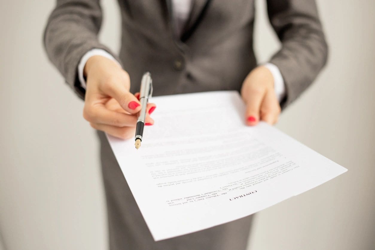 A person in a suit holding a pen and paper